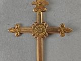 a close up of a gold cross on a white surface