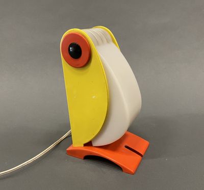 une lampe en forme d'oiseau, jaune et blanche, posée sur un pied