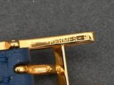 a close up of a gold cuff on a blue bag