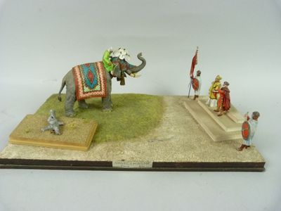 une figurine représentant un éléphant avec un homme assis dessus