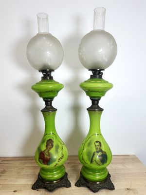 une paire de lampes en verre vert posées sur une table en bois, avec un mur blanc en arrière-plan