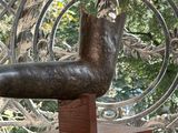 a bronze statue of a bird on a wooden stand