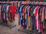 a lot of clothes hanging on a rack in a store