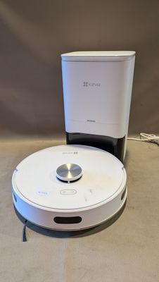 un robot posé par terre à côté d'une cafetière