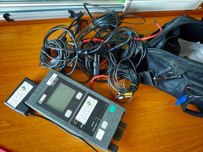 un sac rempli de câbles et un téléphone portable posés sur une table