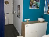une photo d'une salle de bains avec un mur bleu et un lavabo blanc