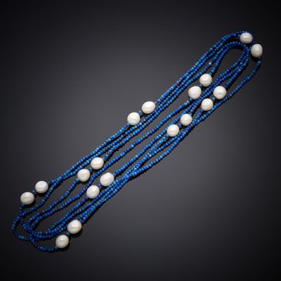 un collier de perles bleues et blanches sur fond noir