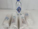 four bottles of water sitting on top of a table covered in plastic wrap