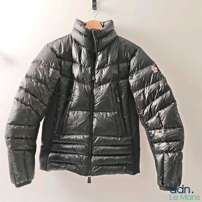 the jacket is hanging on a hanger on the wall