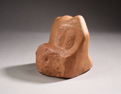 a stone chair that is sitting on a white surface