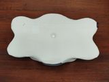 a white plate on a wooden table with a black handle