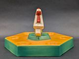 figurine of a man sitting on top of a green and yellow base