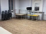 une pièce équipée de tables, de chaises et d'une télévision