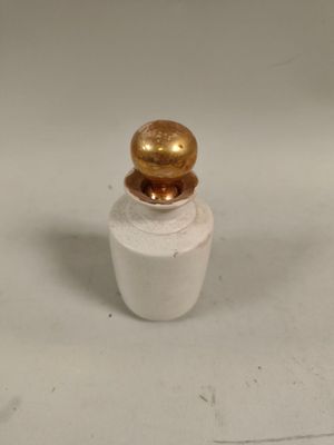 une petite bouteille surmontée d'une boule dorée