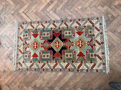 un tapis posé sur un parquet, avec une personne debout à côté
