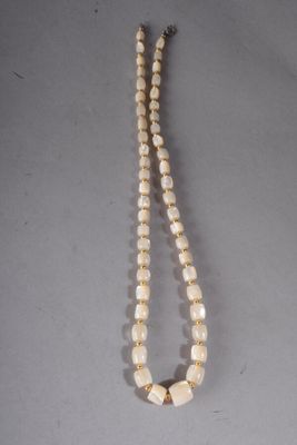 gros plan d'un collier sur une table à fond blanc