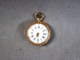 a gold pocket watch with roman numerals on it