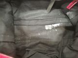 the inside of a black purse with a red handle