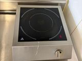 a stove top with a black burner on it in a kitchen