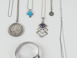 several different necklaces and rings are arranged on a white surface
