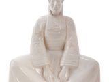 statue of a woman sitting on a white surface with a white background