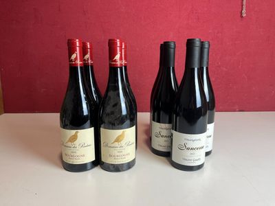 trois bouteilles de vin sont alignées sur une table