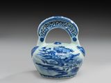 vase bleu et blanc muni d'une anse, sur un fond gris