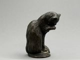 une statue représentant un ours assis sur un socle