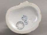 un petit objet en porcelaine sur lequel est représenté un chat