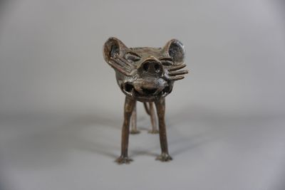 un petit animal en métal posé sur une surface blanche