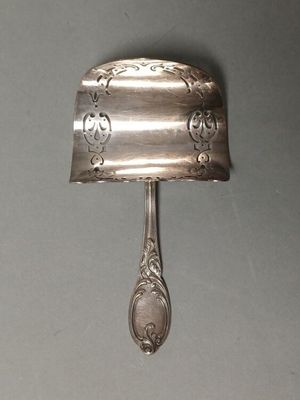 a silver spoon and spoon rest on a wall