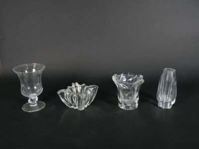 four glass vases are lined up on a black surface