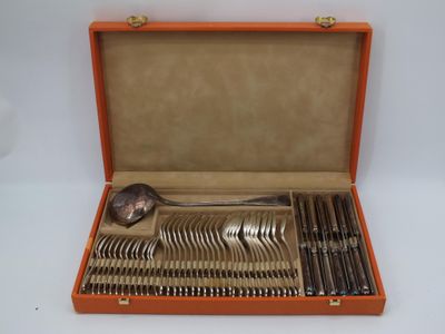 an orange case holds a set of silverware including a spoon, spoon and spoon rest