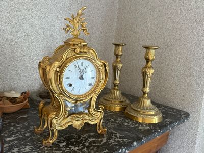 une horloge en or posée sur une table en marbre