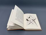 an open book with a drawing of a star on it