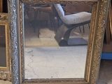 a picture of a mirror sitting on the floor next to a chair