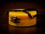 une petite boîte jaune entourée d'un ruban noir