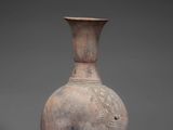 a vase that is sitting on a stand on a gray surface