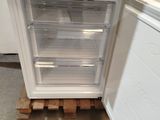 a small white refrigerator in the corner of a room