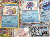 several pokemon cards are on a table with a lot of other pokemon cards