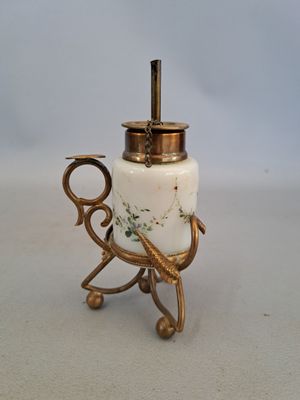 un vase blanc et doré muni d'une anse, posé sur une table