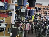 de nombreux vélos dans un magasin où sont accrochés de nombreux sacs au mur
