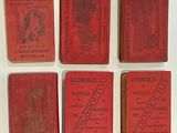 six red books are lined up on a white surface