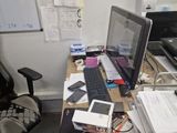 a desk with a laptop, phone, and other items on it