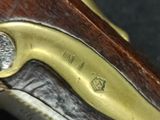 a close up of a gun with a brass handle