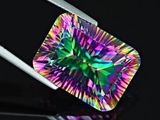 a close up of a colorful diamond on a black surface