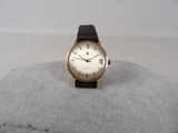an image of a gold wrist watch with a black strap