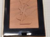 a close up of a compact powder blush on a white surface