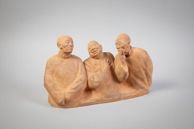 deux figurines représentant trois hommes assis sur une dalle de pierre