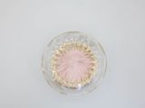 a glass bowl with a pink flower inside of it
